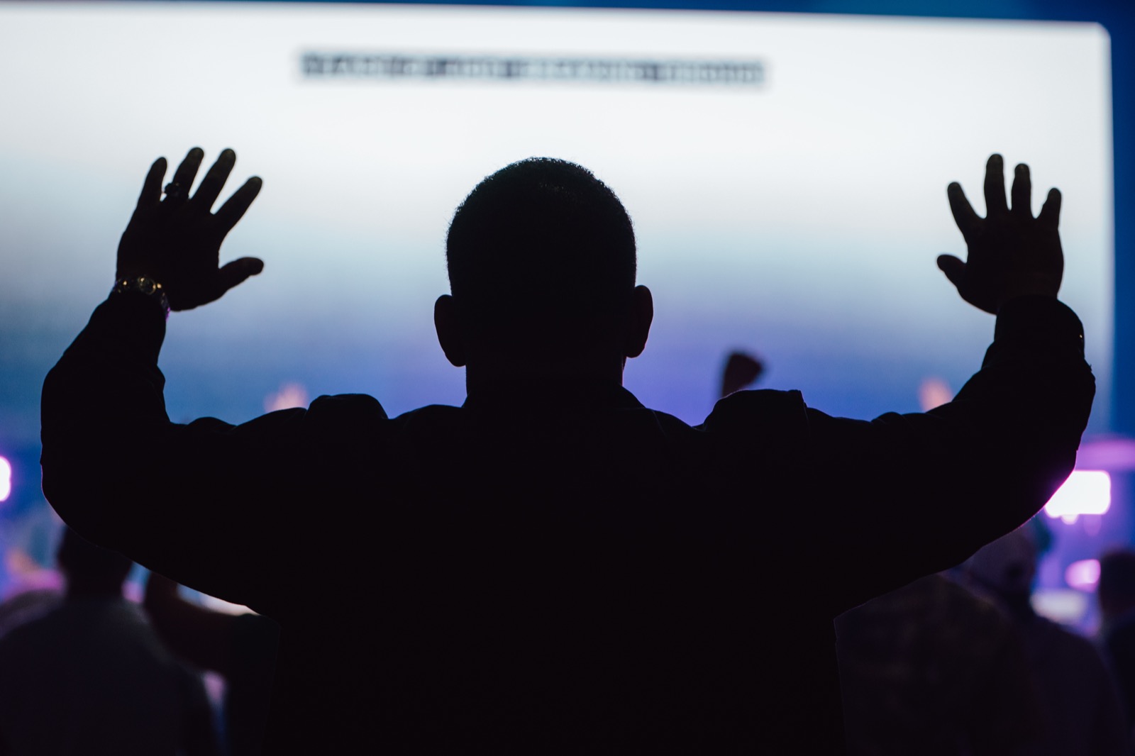 A worshipper with hands raised during an ILM retreat gathering
